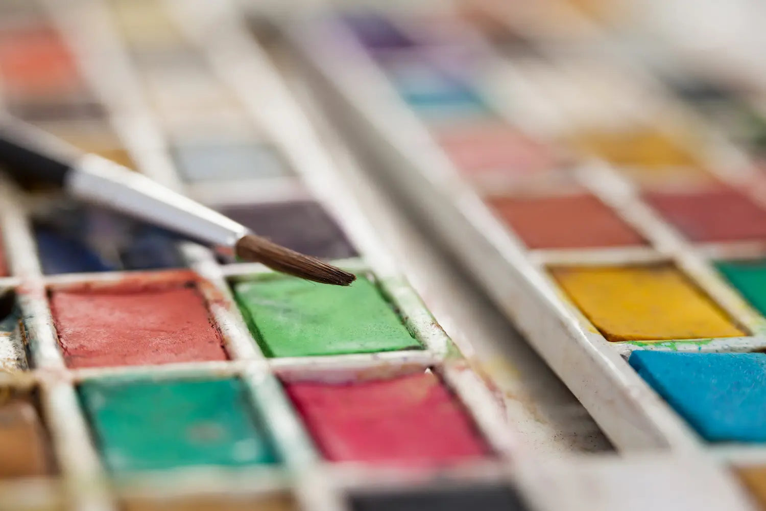 Close up of a watercolour palette and paintbrush